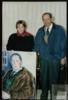 Miguel Delibes Setién junto a una mujer con el retrato que ha hecho del escritor.